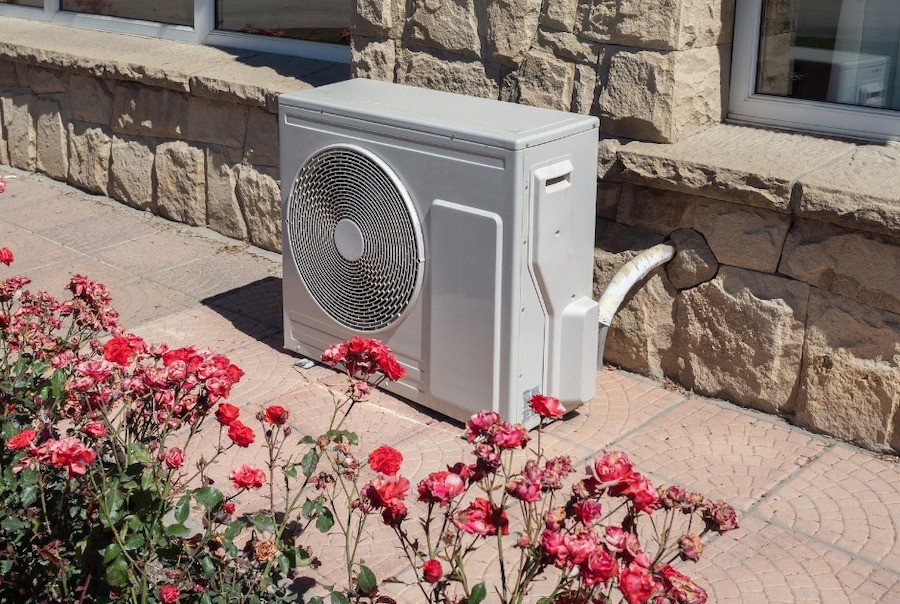 outdoor condenser unit of a multi-split AC system on stone pavers.